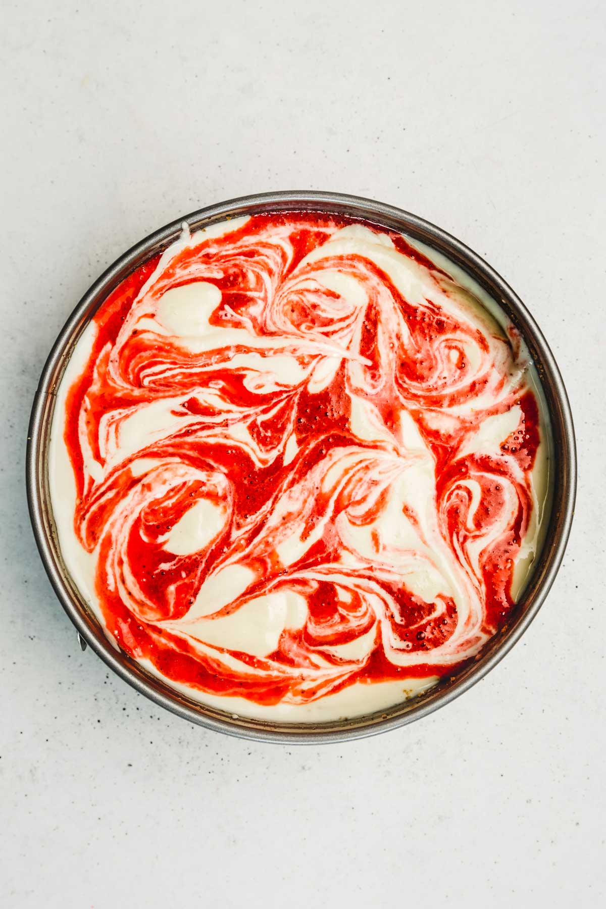 Spring form pan with cheesecake batter befor baking