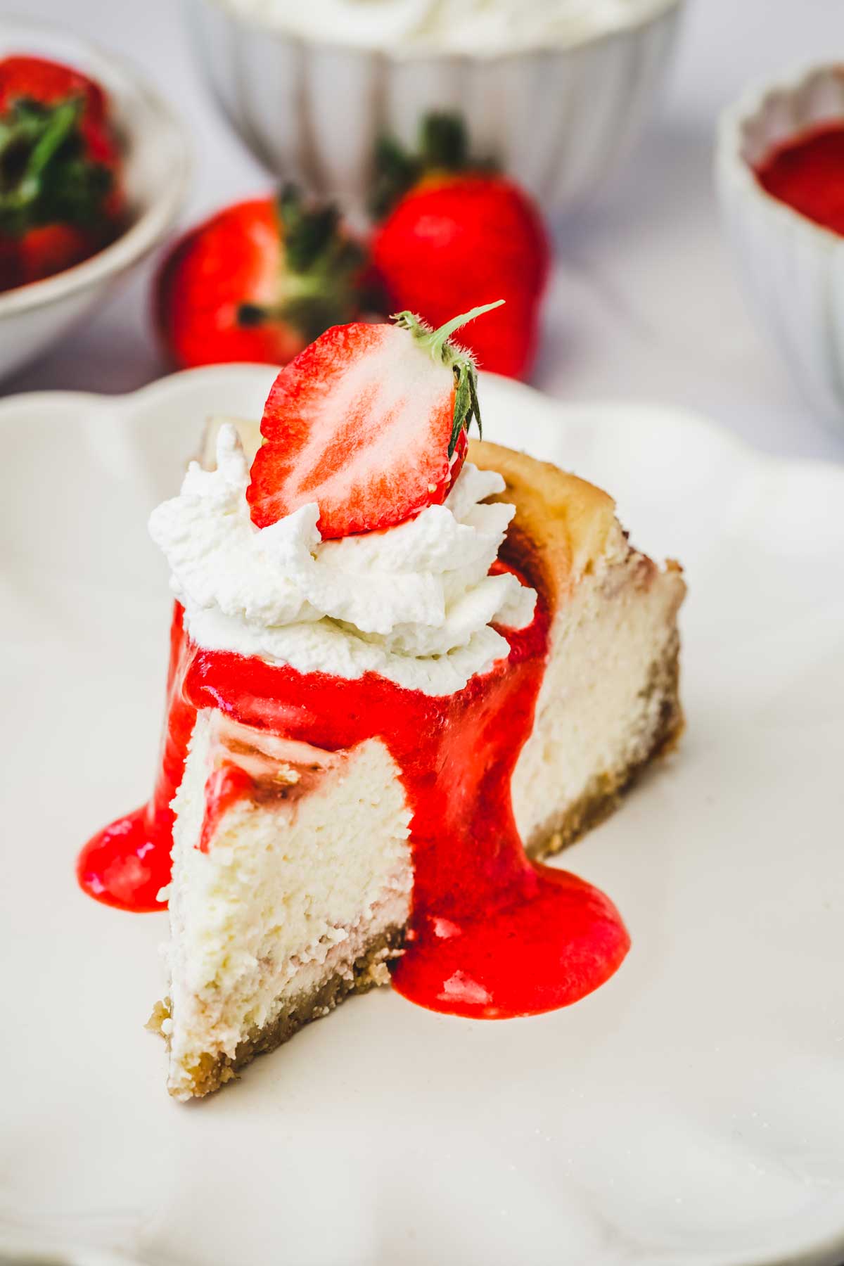 Part de cheesecake aux fraises avec du coulis de fraises et de la chantilly maison