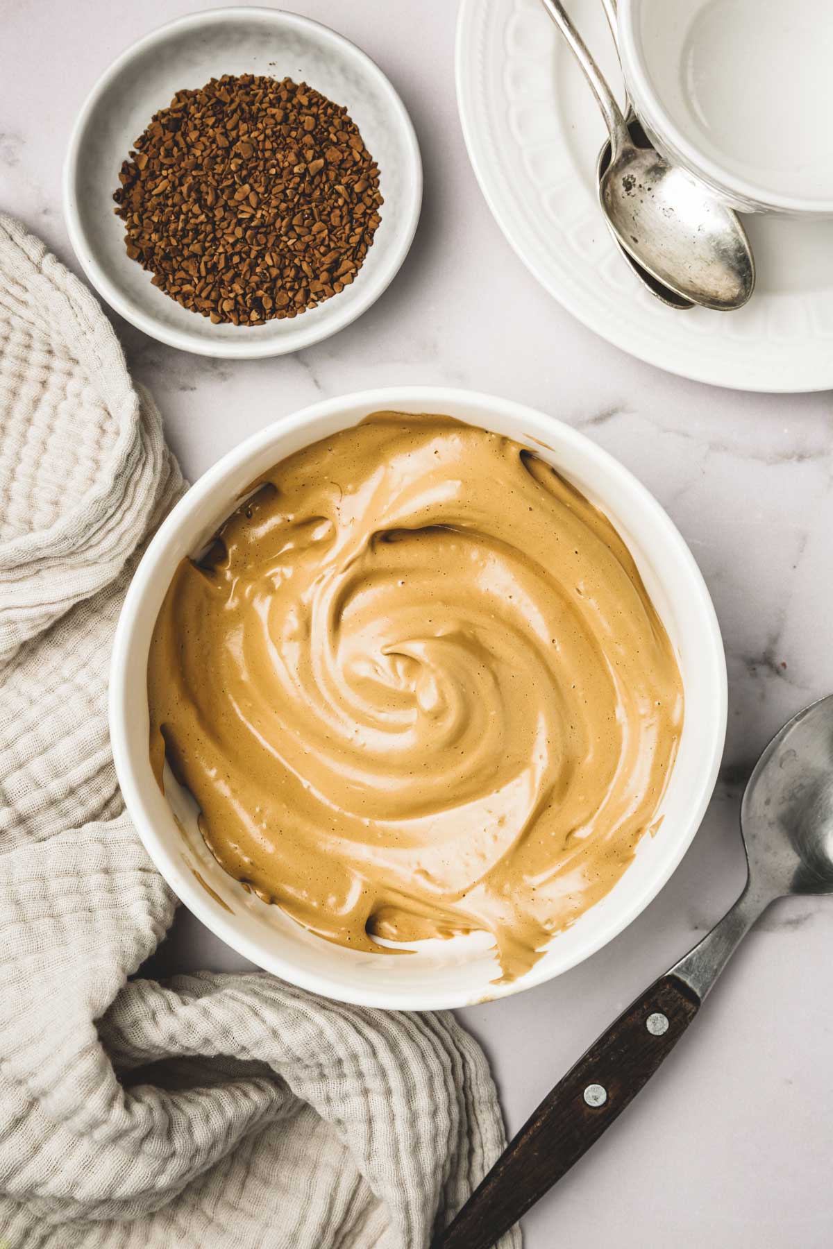 Small bowl on a table with a cloth and a spoon
