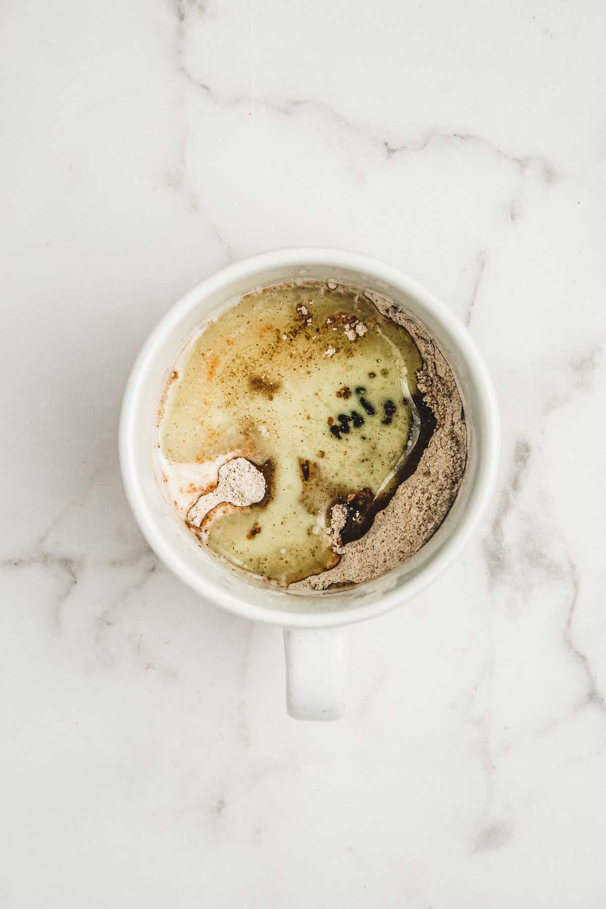 Mug with mixed dry and wet ingredients for hot cocoa mug cake