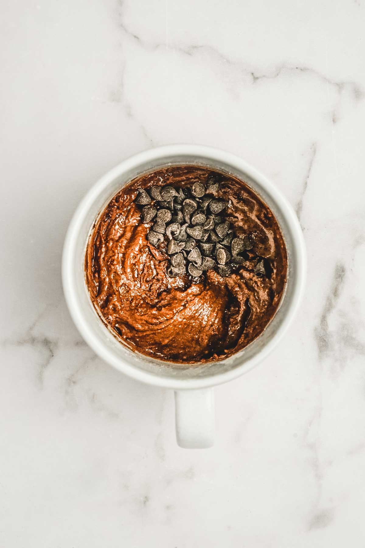 Mug with cake batter and chocolate chips