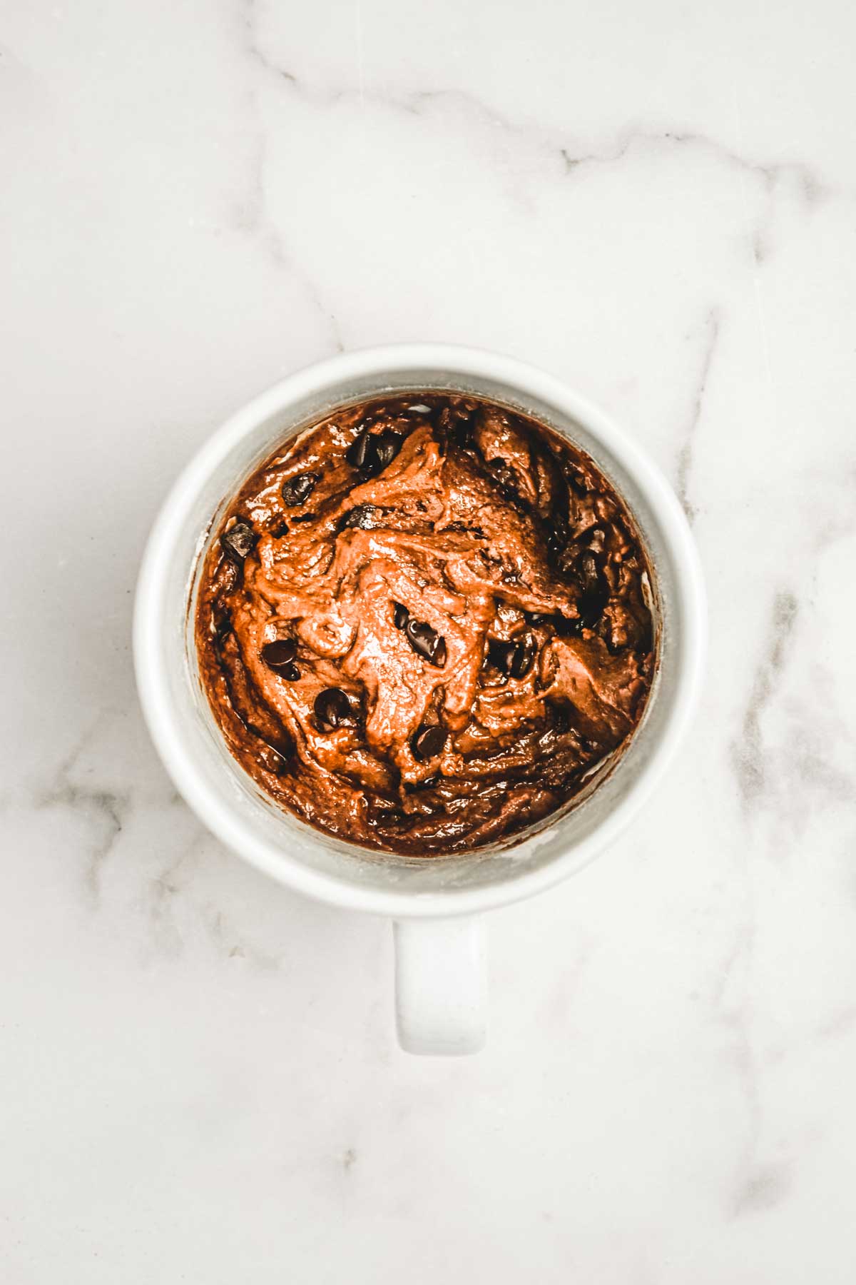 Mug with chocolate cake batter before baking
