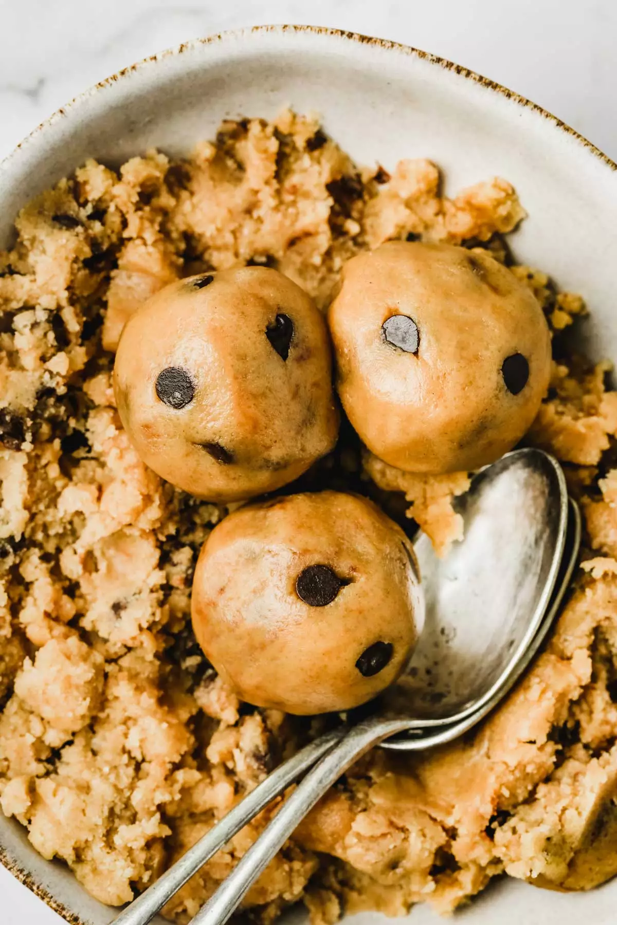 Bol avec de la cookie dough et des cuillères