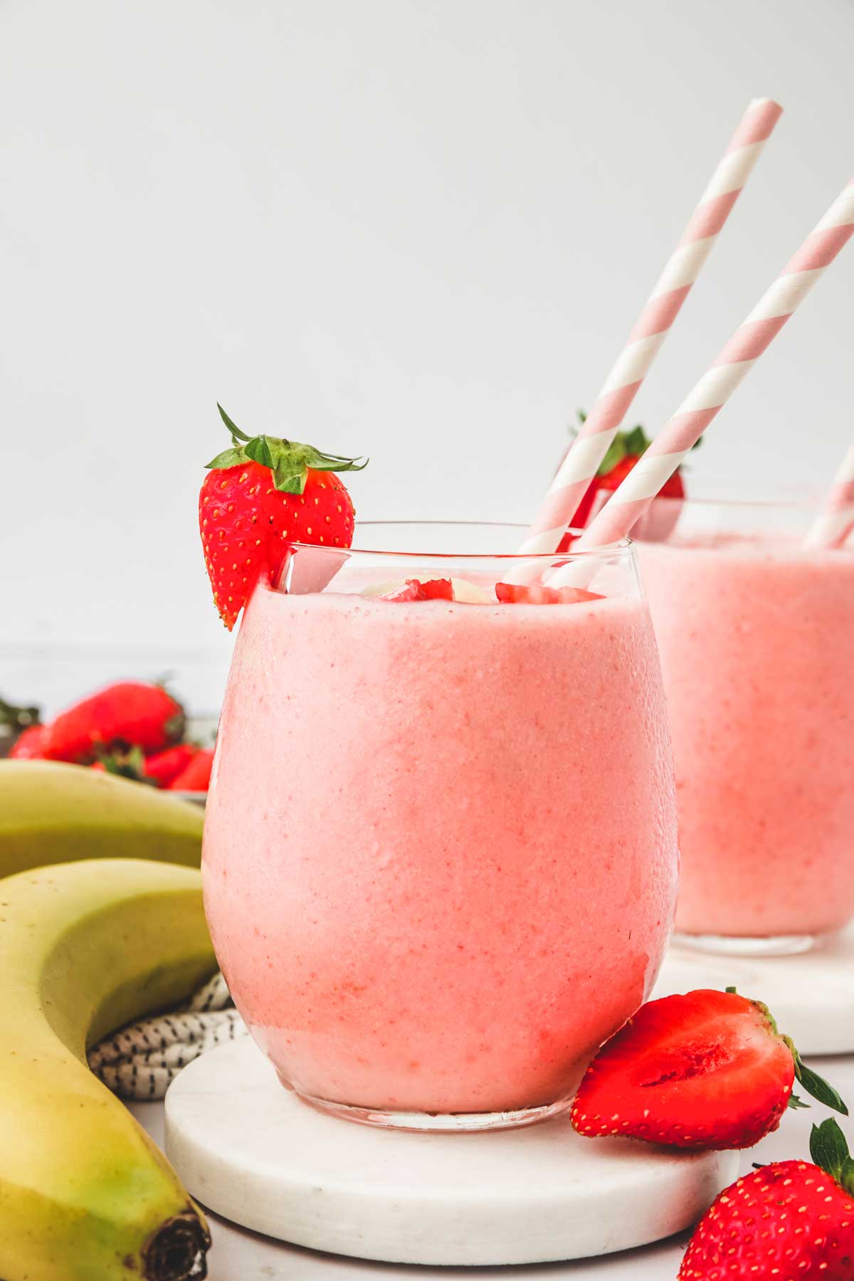 2 verres remplis de smoothie fraise banane et des pailles