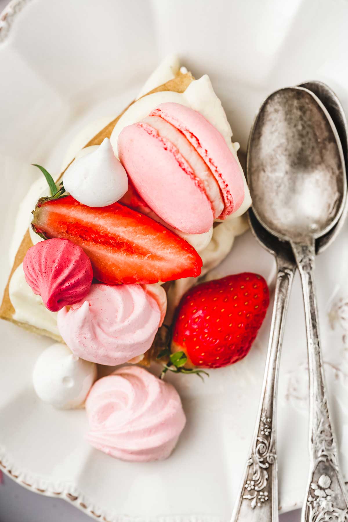 Piece of number cake with teaspoons of meringue and strawberry