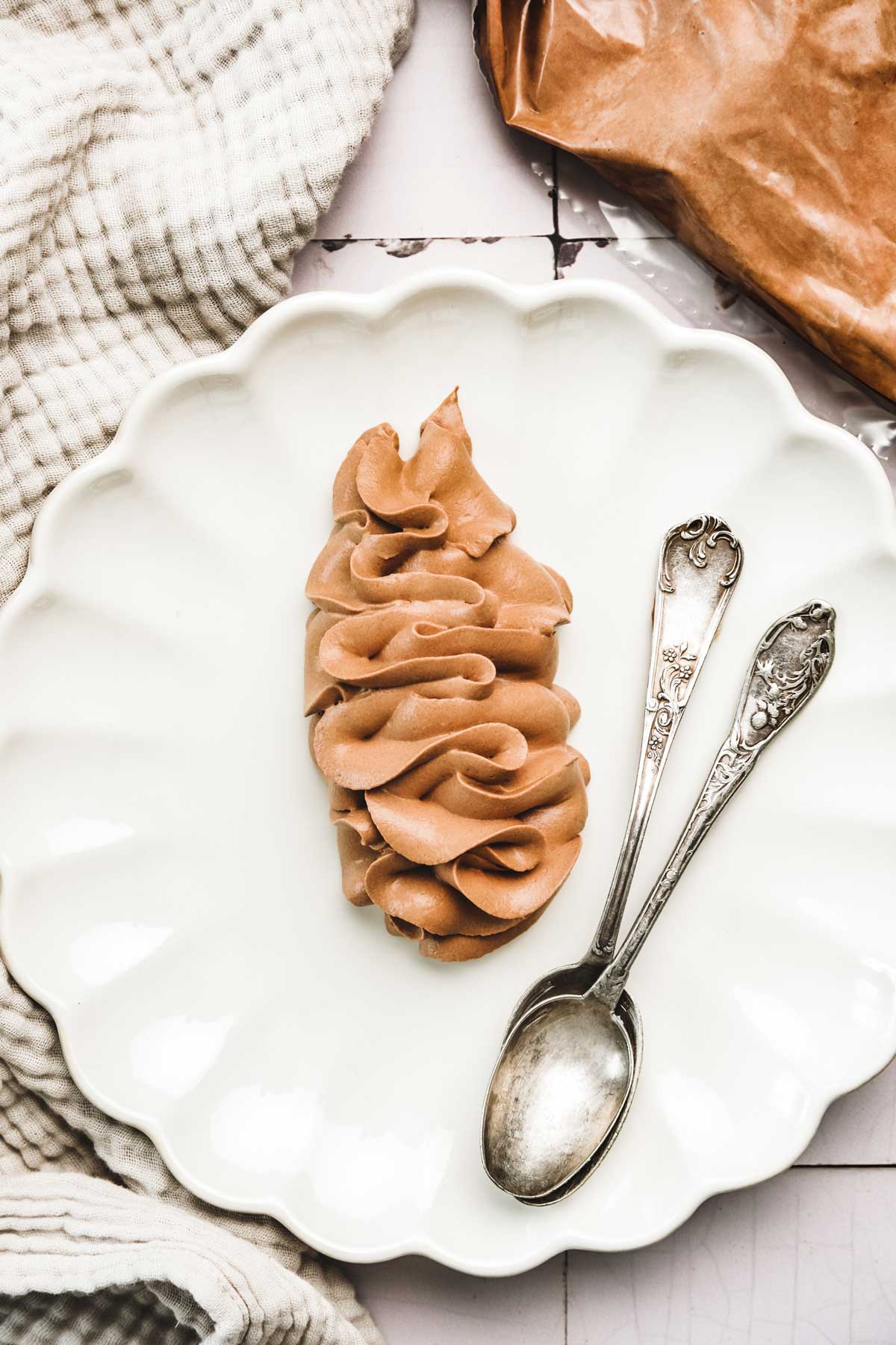 Plate on a table with chocolate whipped ganache and small spoons
