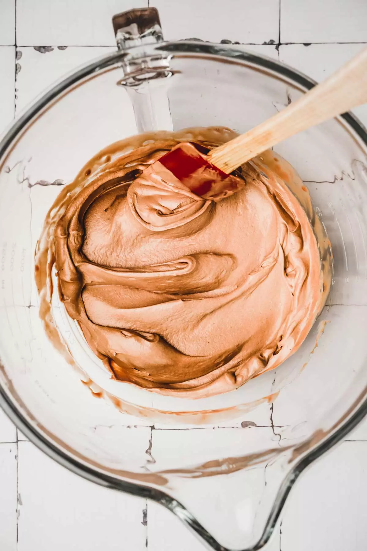 Whipped chocolate ganache frosting in a mixing bowl