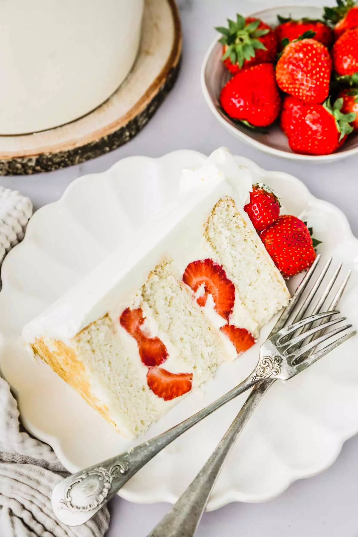 Piece of strawberry layer cake in a plate with forks