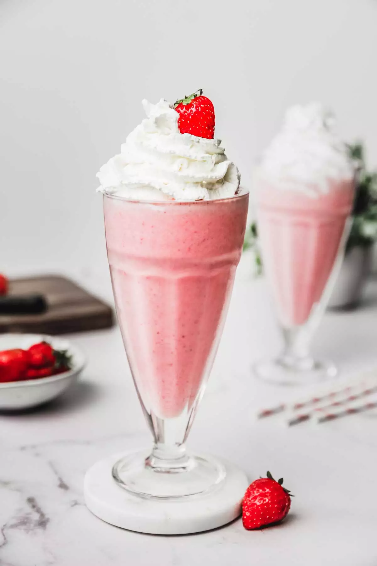 2 grands verre de milkshake aux fraises avec chantilly et fraise