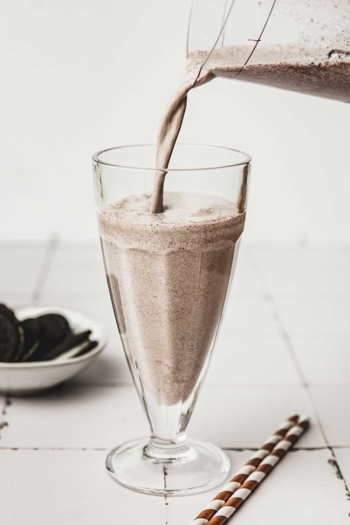 Milkshake poured into a large glass on a table