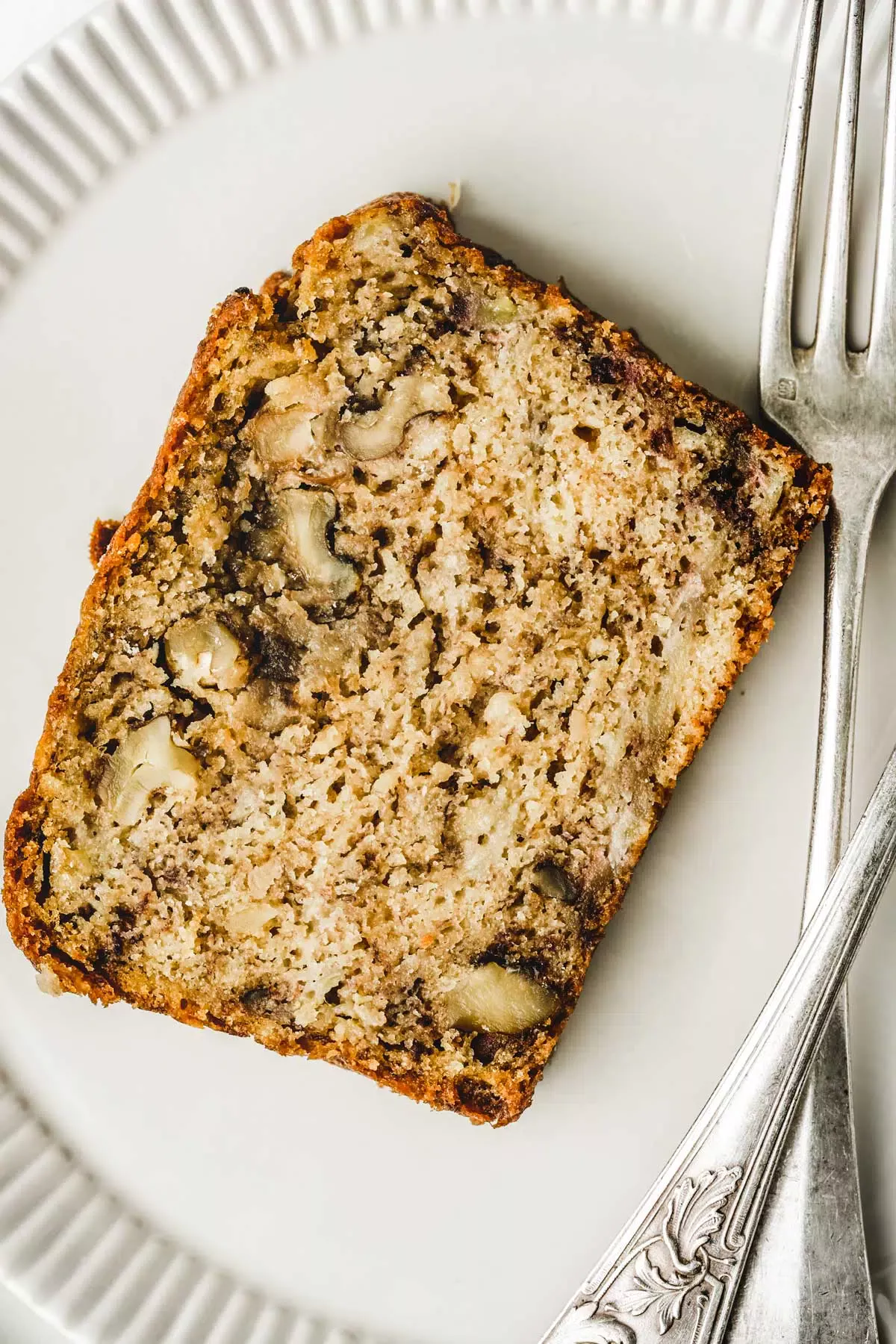 Banana nut cake slice on a plate with forks