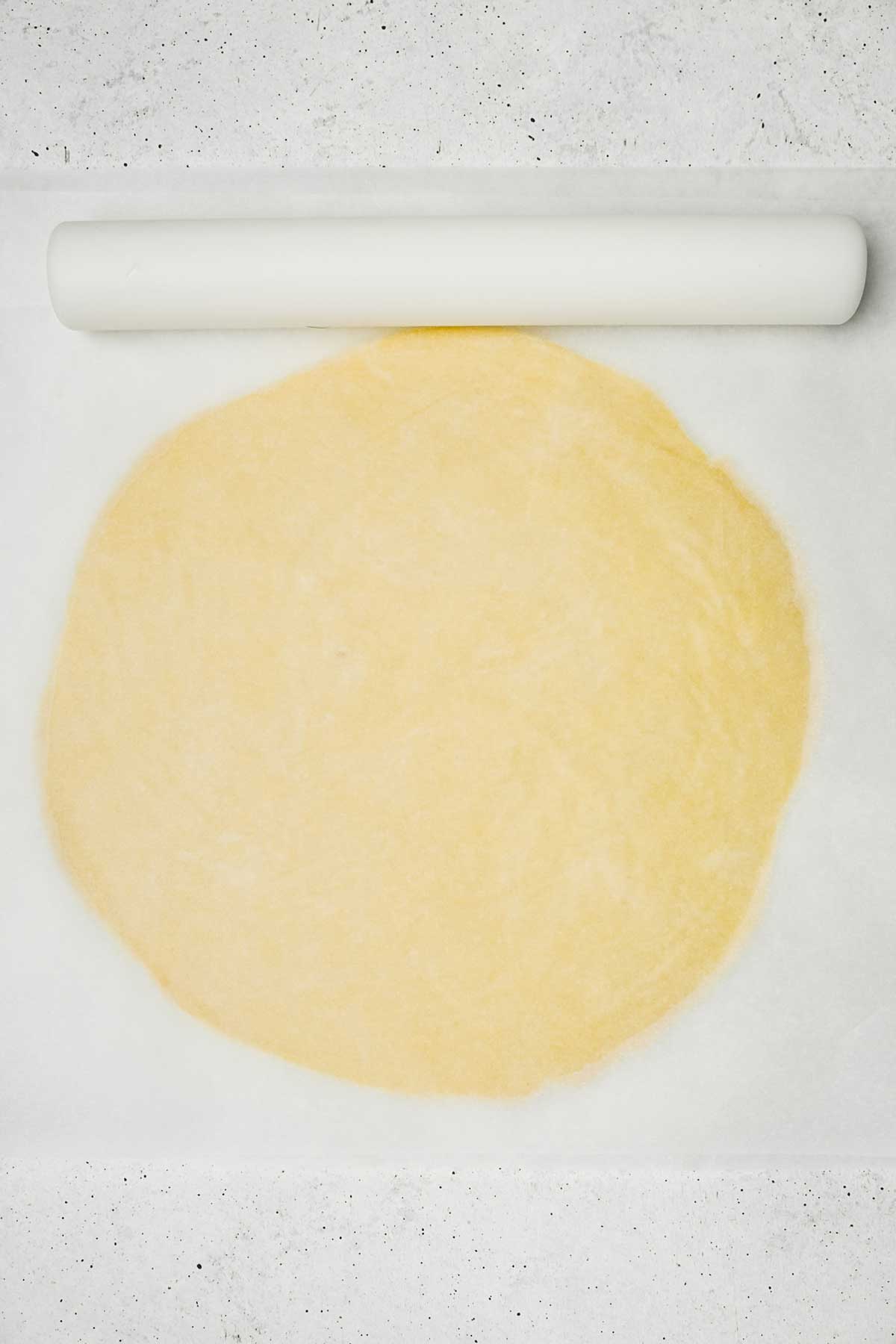rolled sugar cookie dough on parchment paper