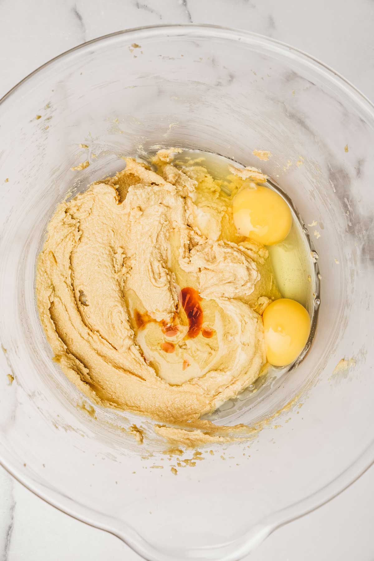 Grand bol avec des oeufs et du beurre et du sucre 