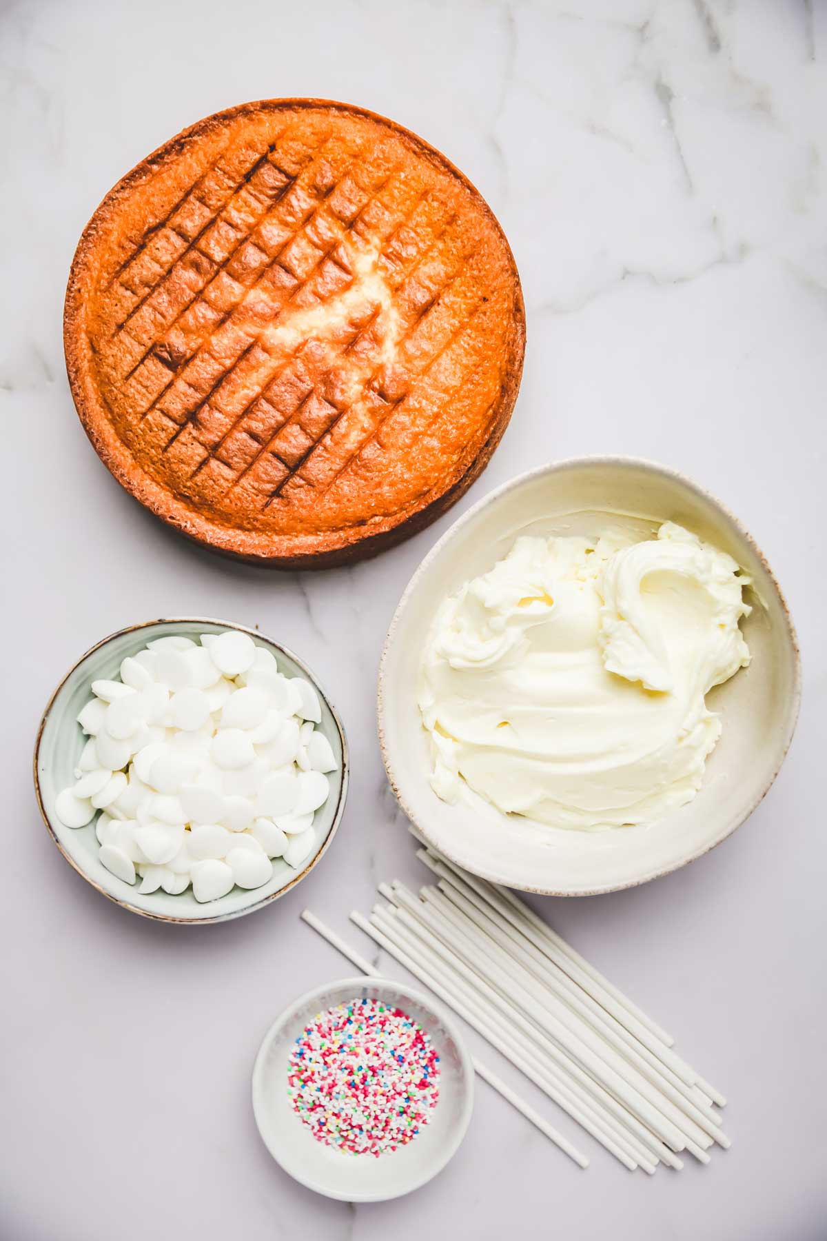 Sponge cake with bowls, icing and lollipop sticks