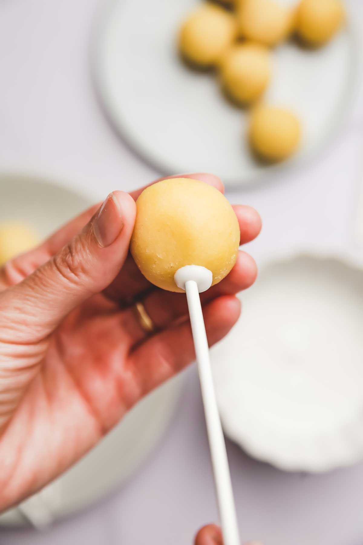 Cake pop in one hand with stick