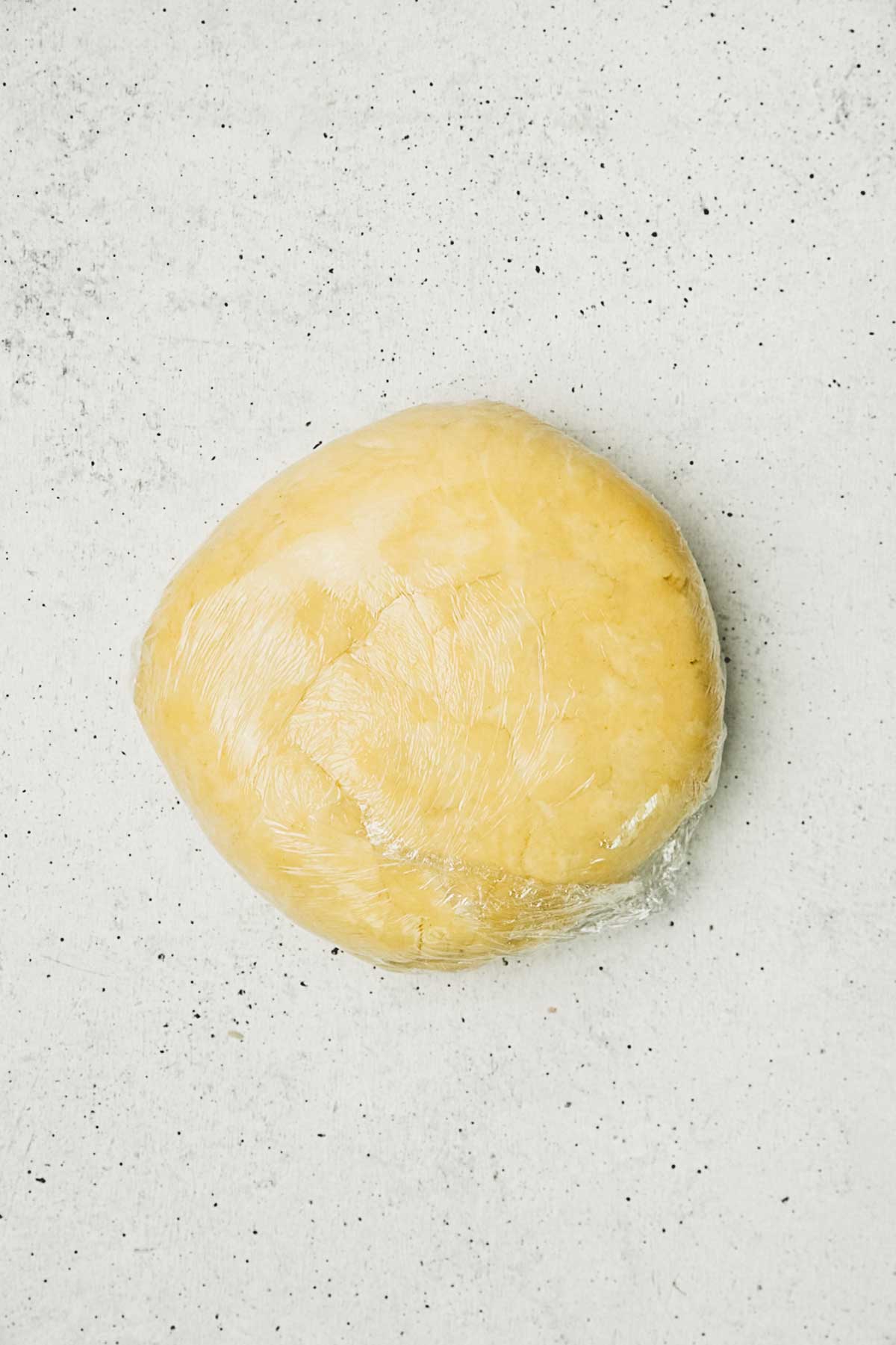 Pâte à tarte maison enveloppée dans du film alimentaire pour tarte au citron meringuée