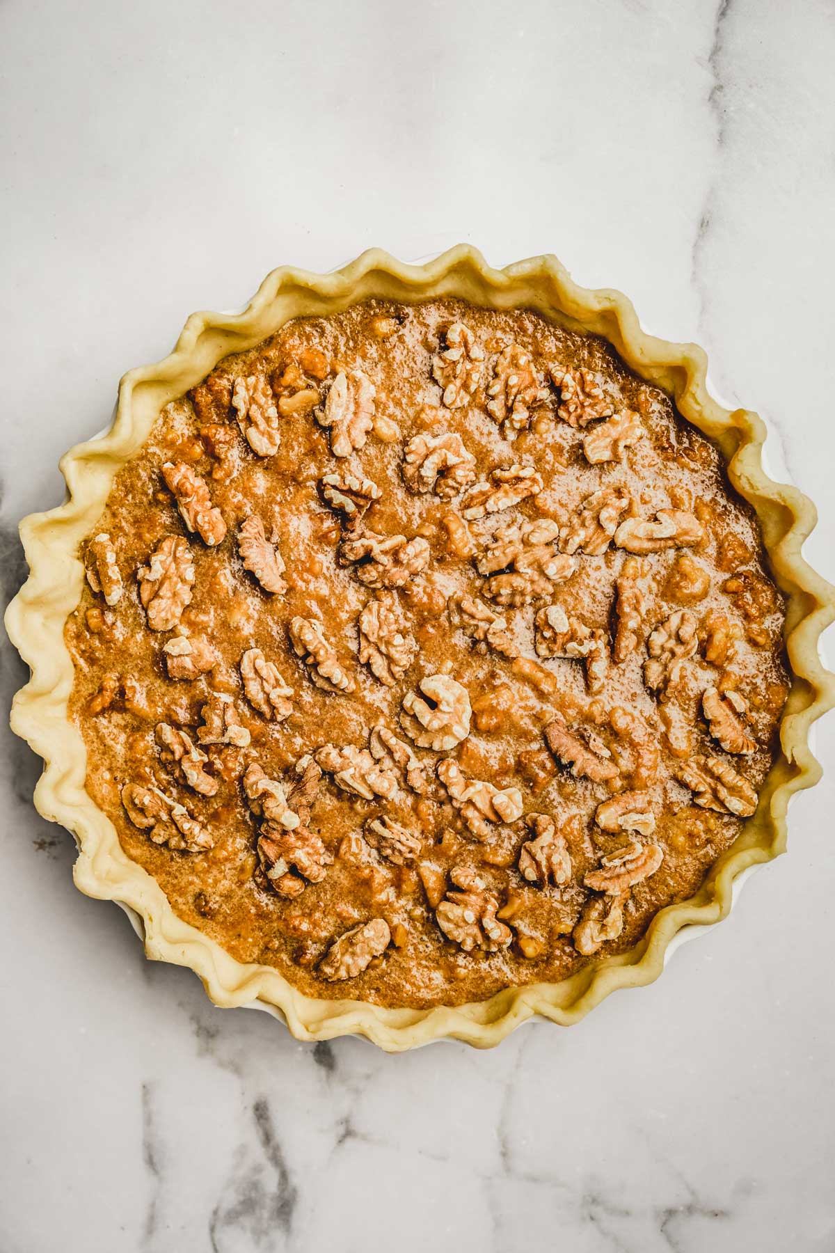 Moule à tarte avec une tarte aux noix avant cuisson