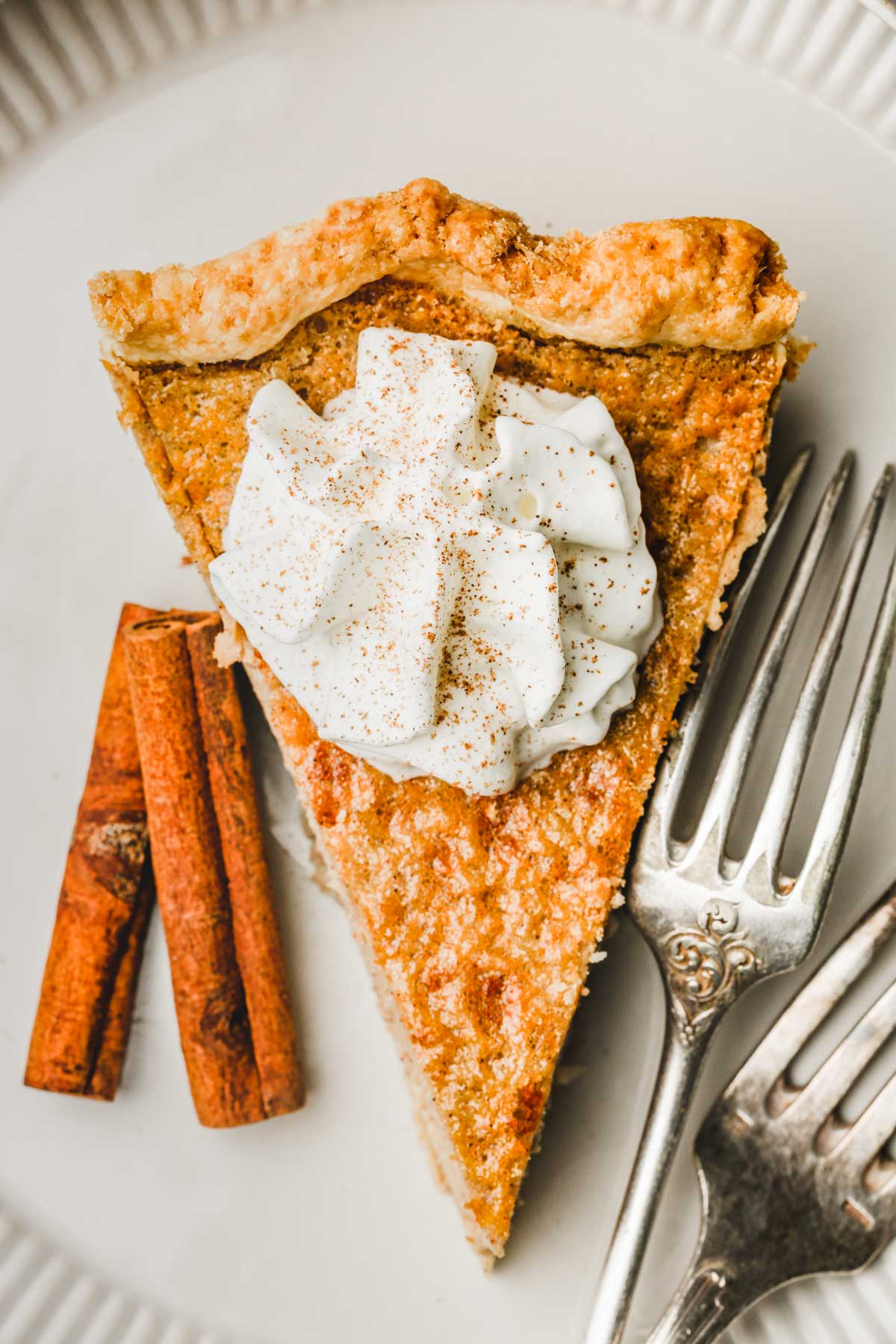 part de tarte à la cannelle avec de la chantilly sur une assiette