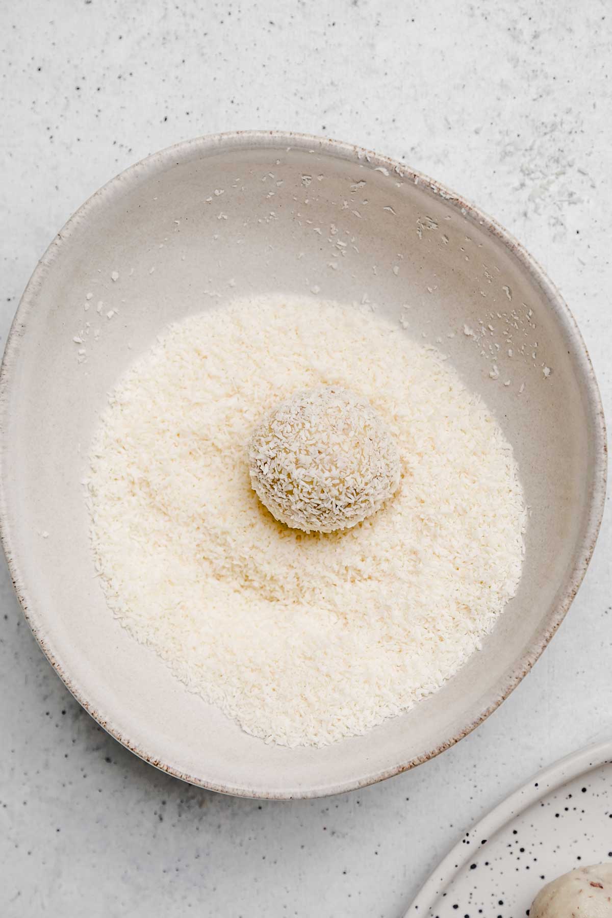 coconut truffles on a bowl with shredded coconut