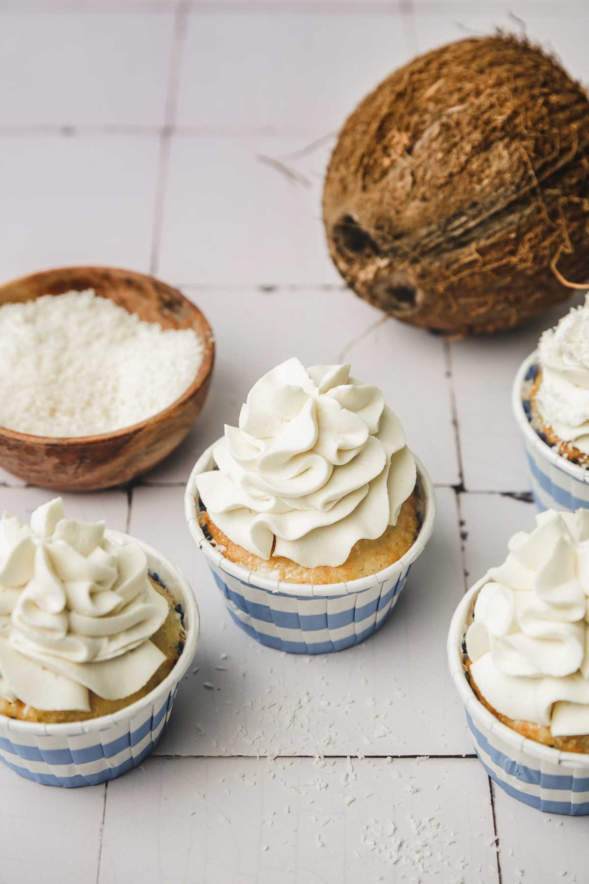 Cupcakes topped with coconut frosting on a table