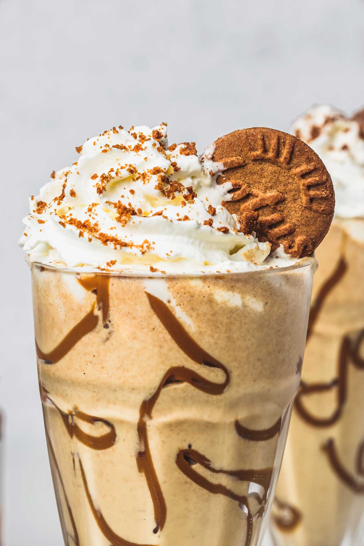 2 glasses of biscoff milkshake on a table