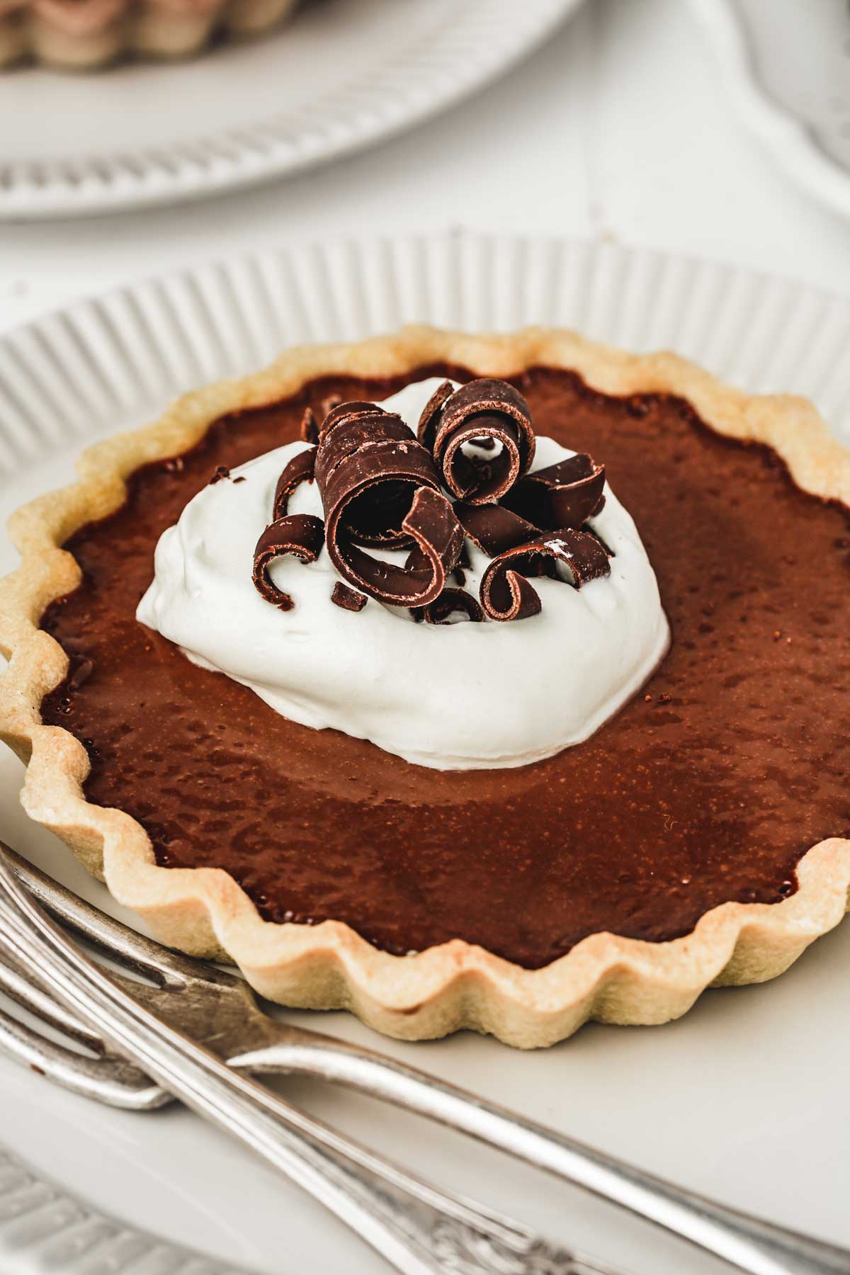 chocolate tart with whipped cream on  a plate