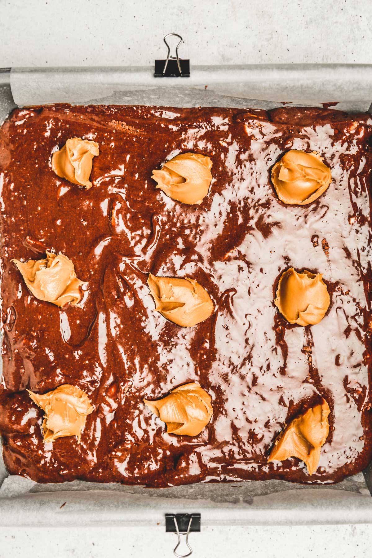 moule avec de la pâte à brownies et des tas de pâte à tartiner lotus