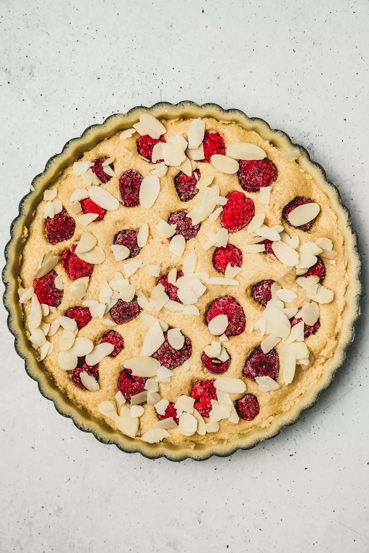 moule à tarte avec une tarte amandine aux framboises