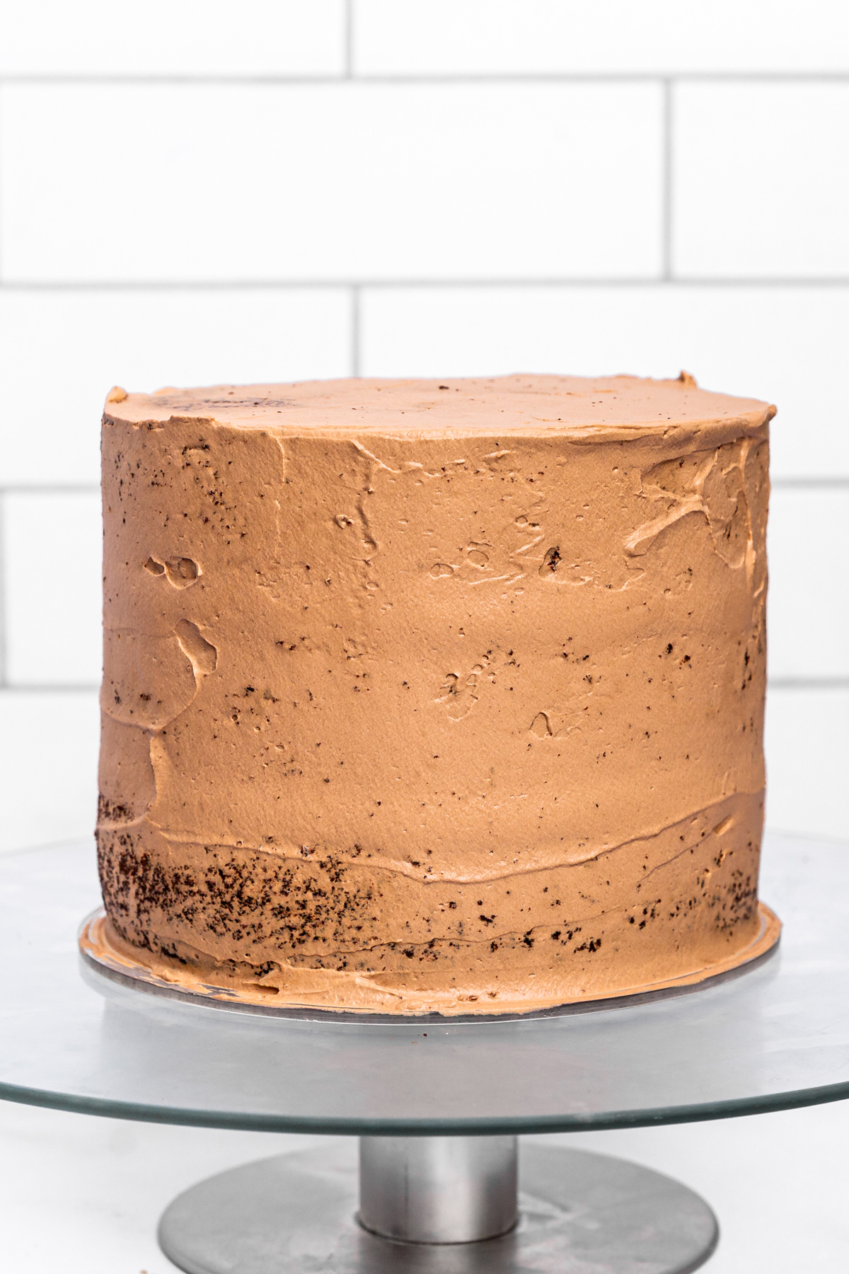 chocolate birthday cake assembly with crumb coat frosting