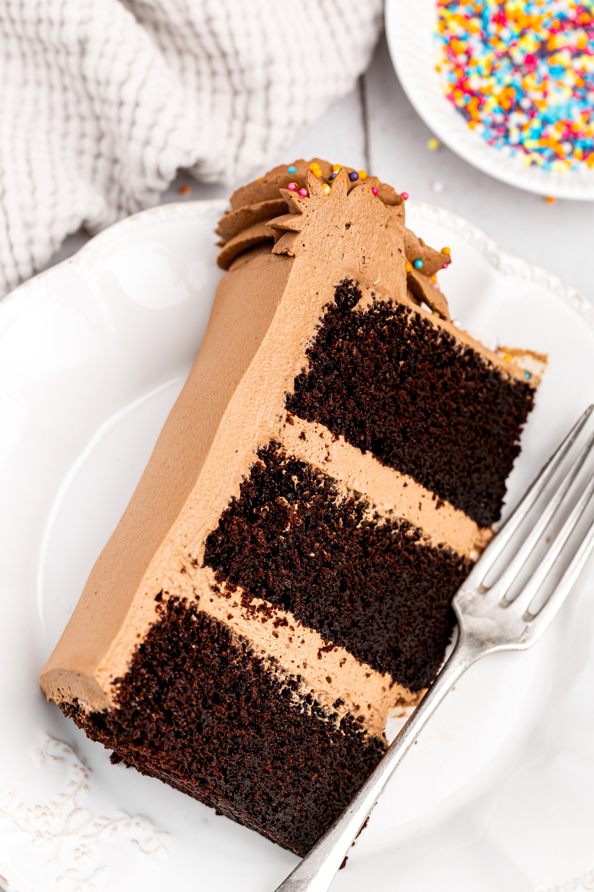 slice of chocolate birthday cake with soft layers and creamy frosting