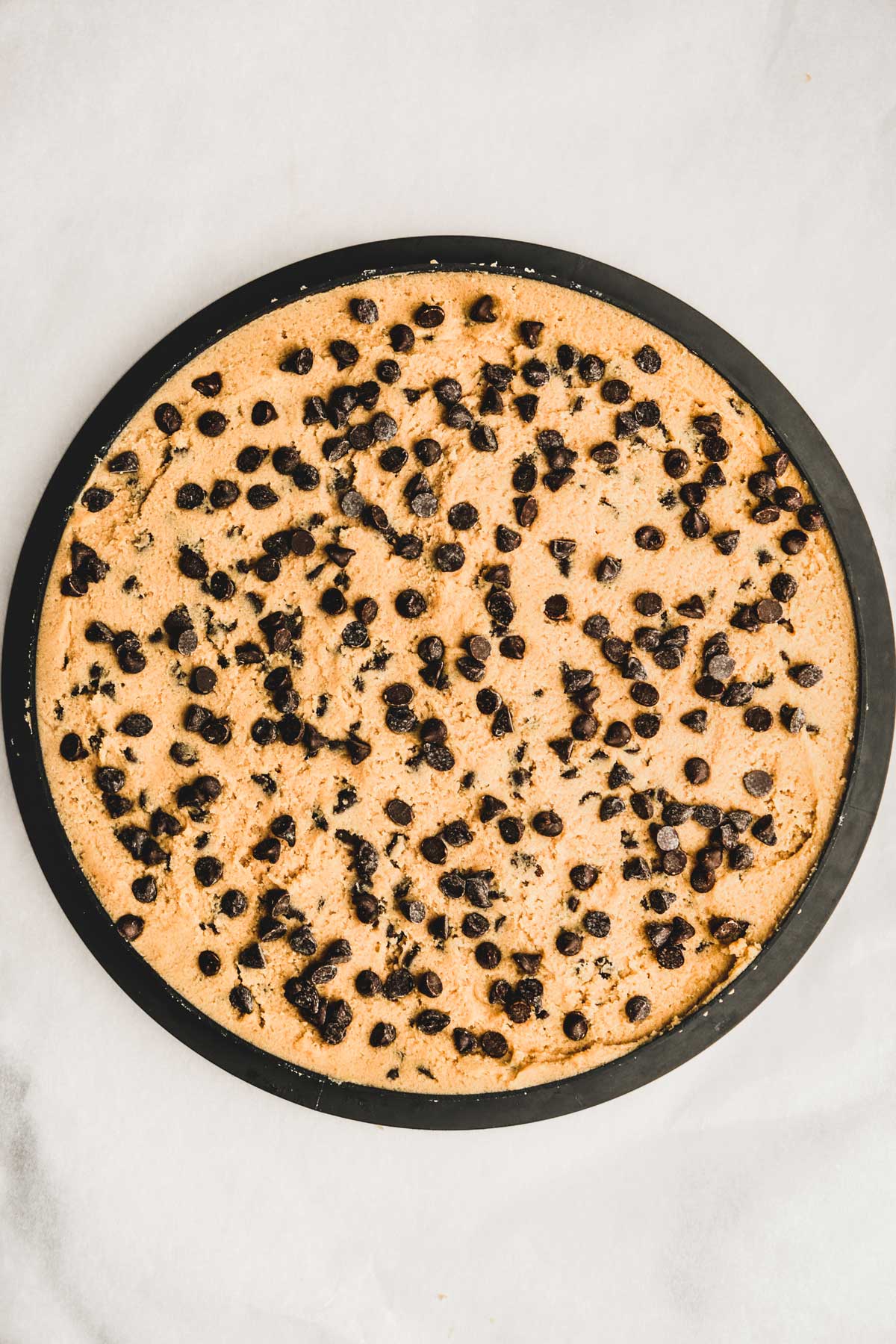 baking sheet with a tart ring and chocolate chip cookie batter