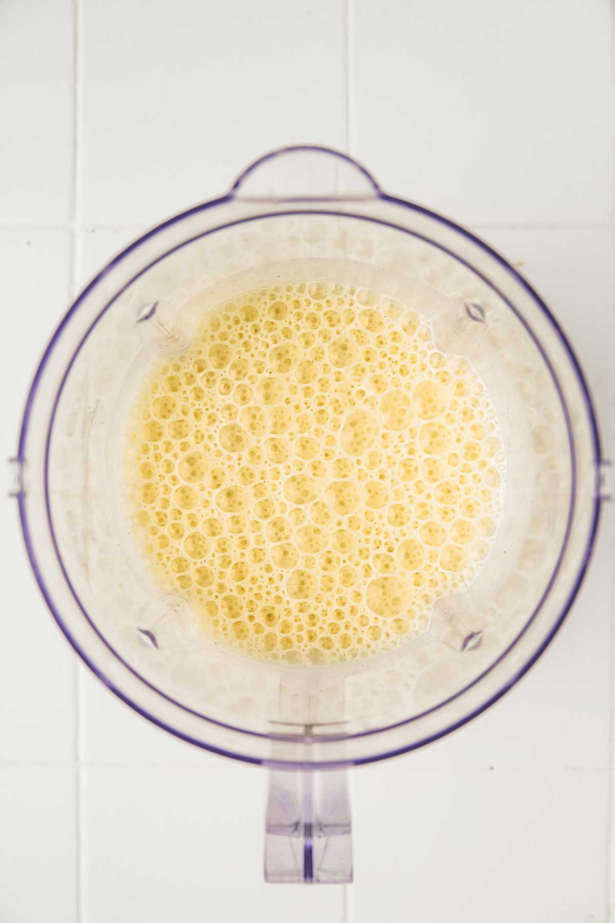 blender bowl with banana milkshake mixture