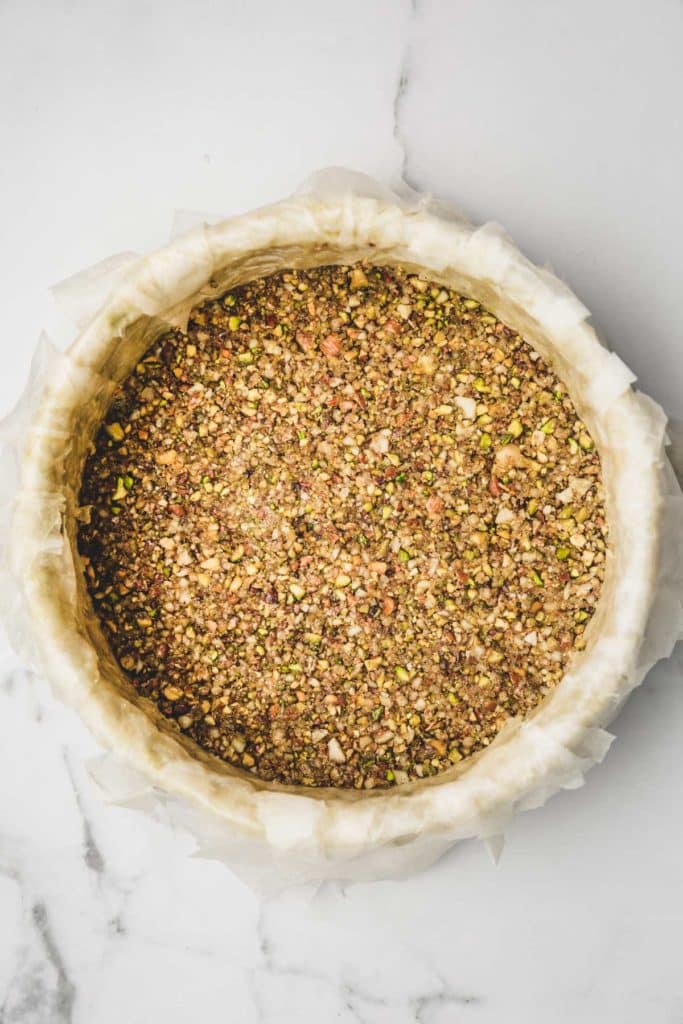 springform pan with crushed nuts and phyllo sheets