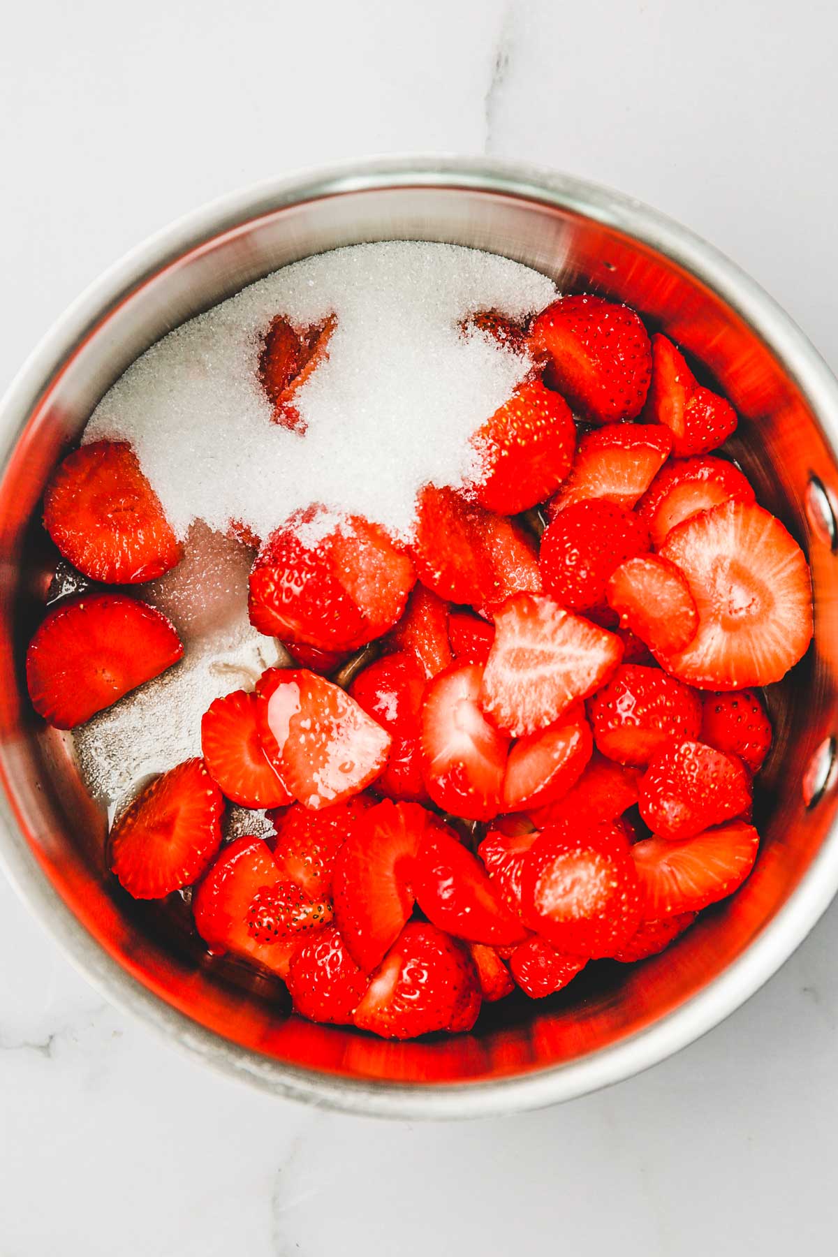 small saucepan with strawberrie and sugar