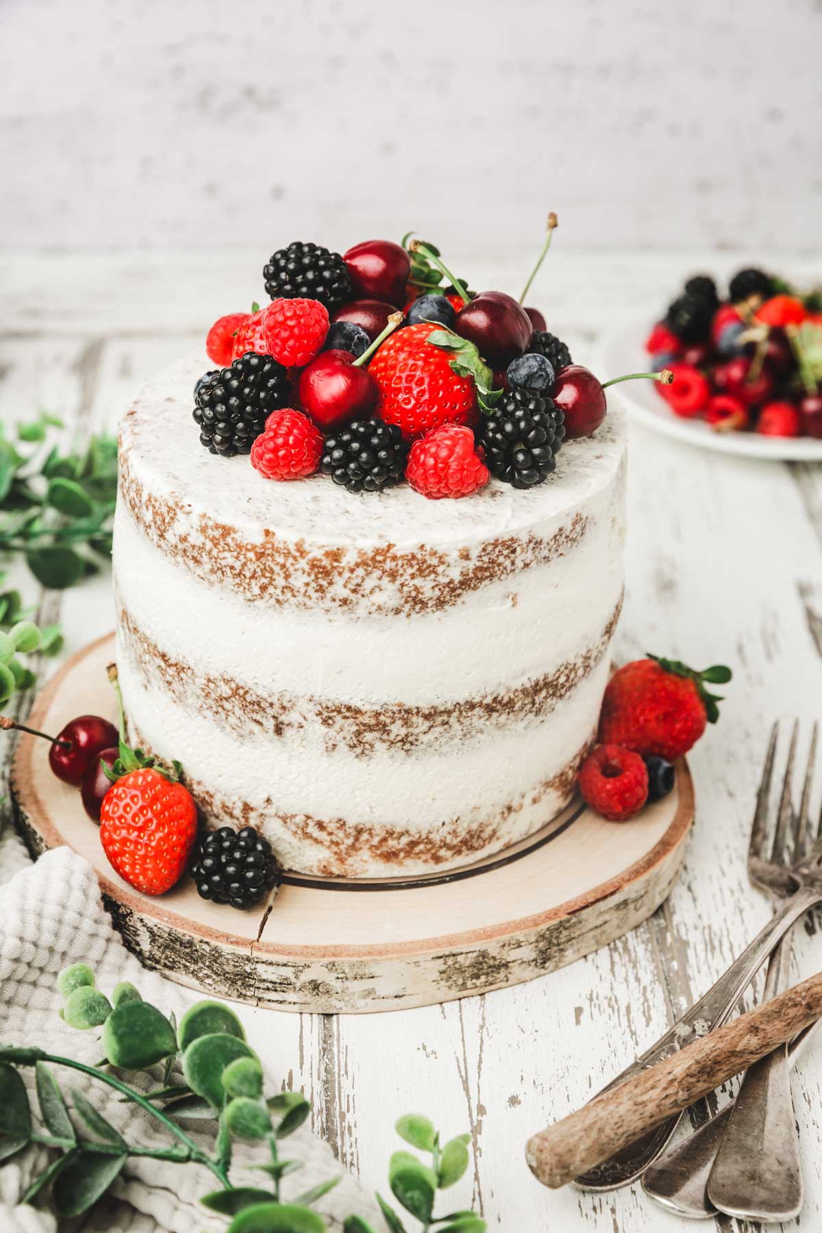 semi-naked cake on a table with fresh berries