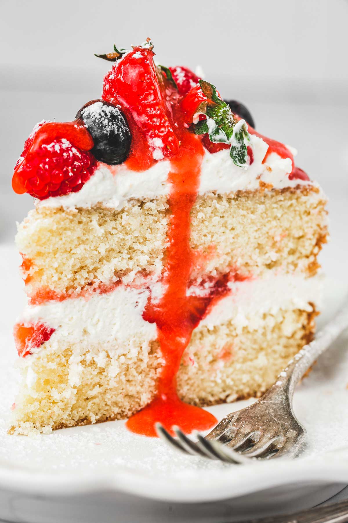 a slice of a berry cake with a strawberry coulis