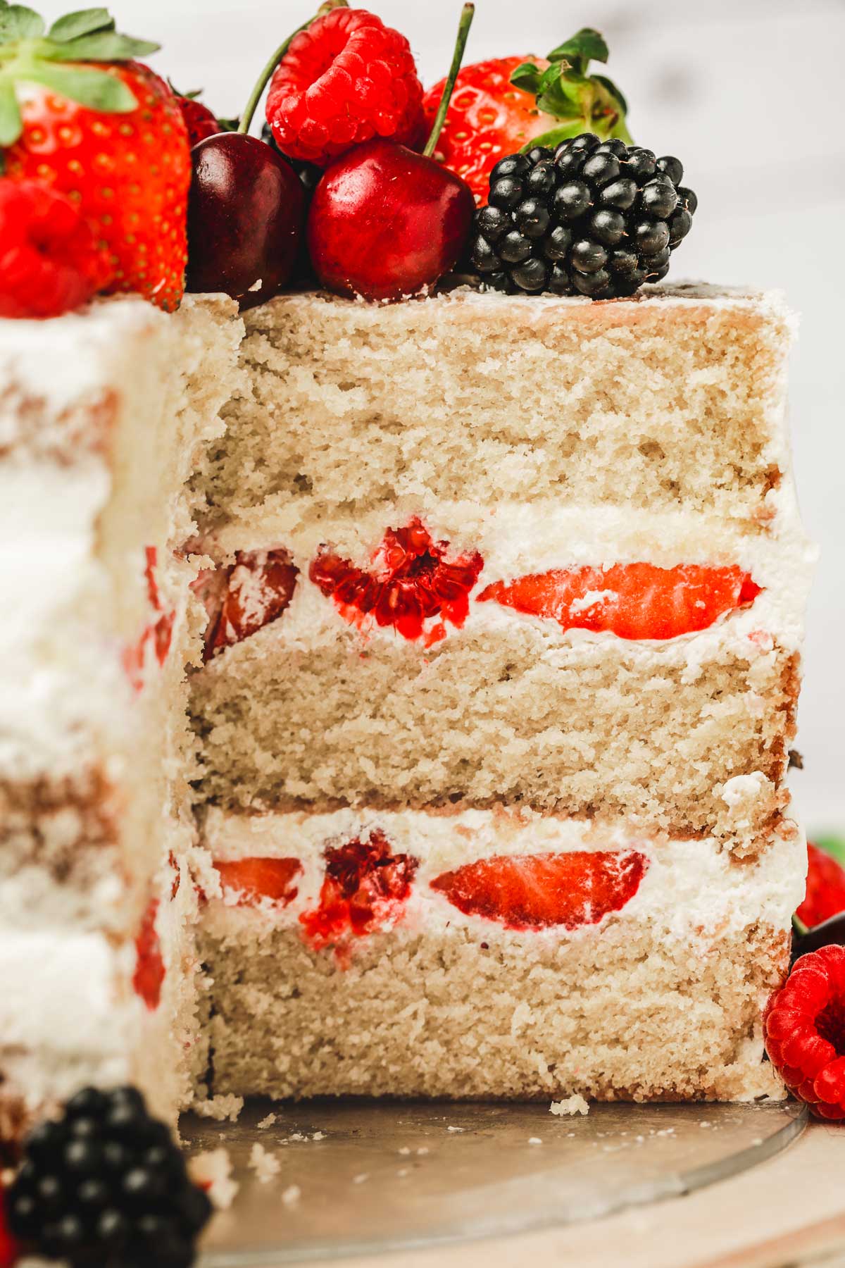 How to make a perfect naked cake recipe semi naked cake with fresh berries cutted on a table