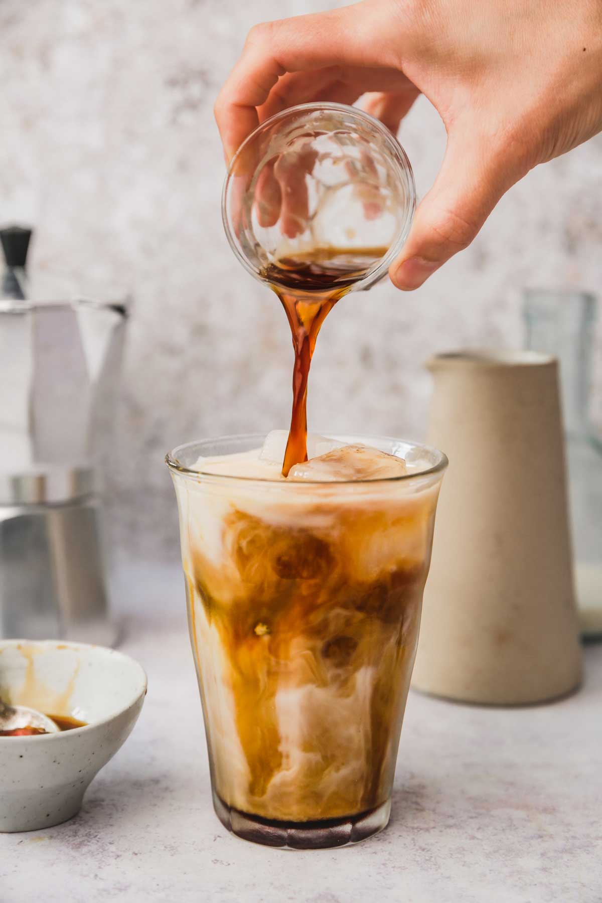 coffee poured in a glass with milk and caramel sauce