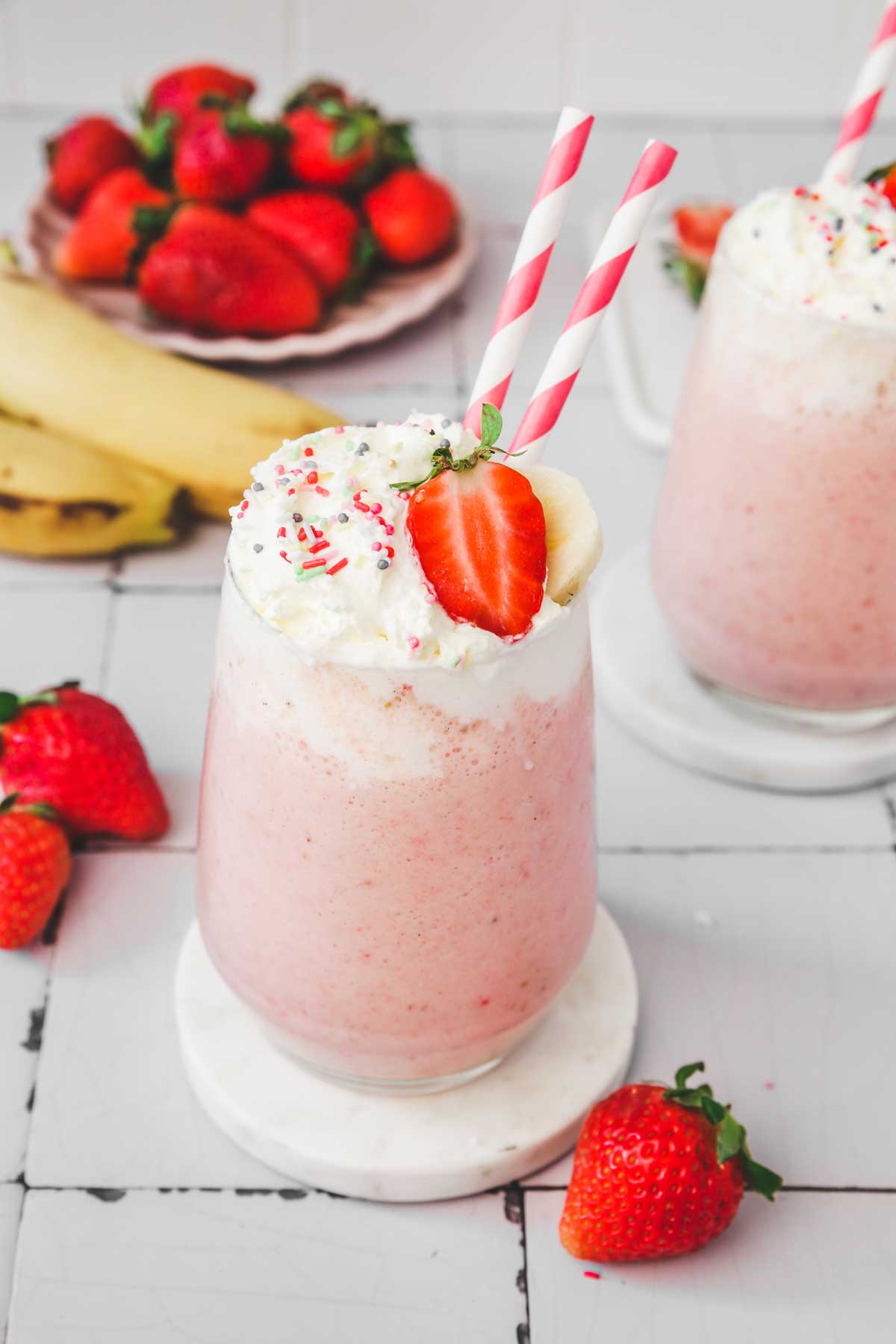 2 strawberry banana milkshake on a table