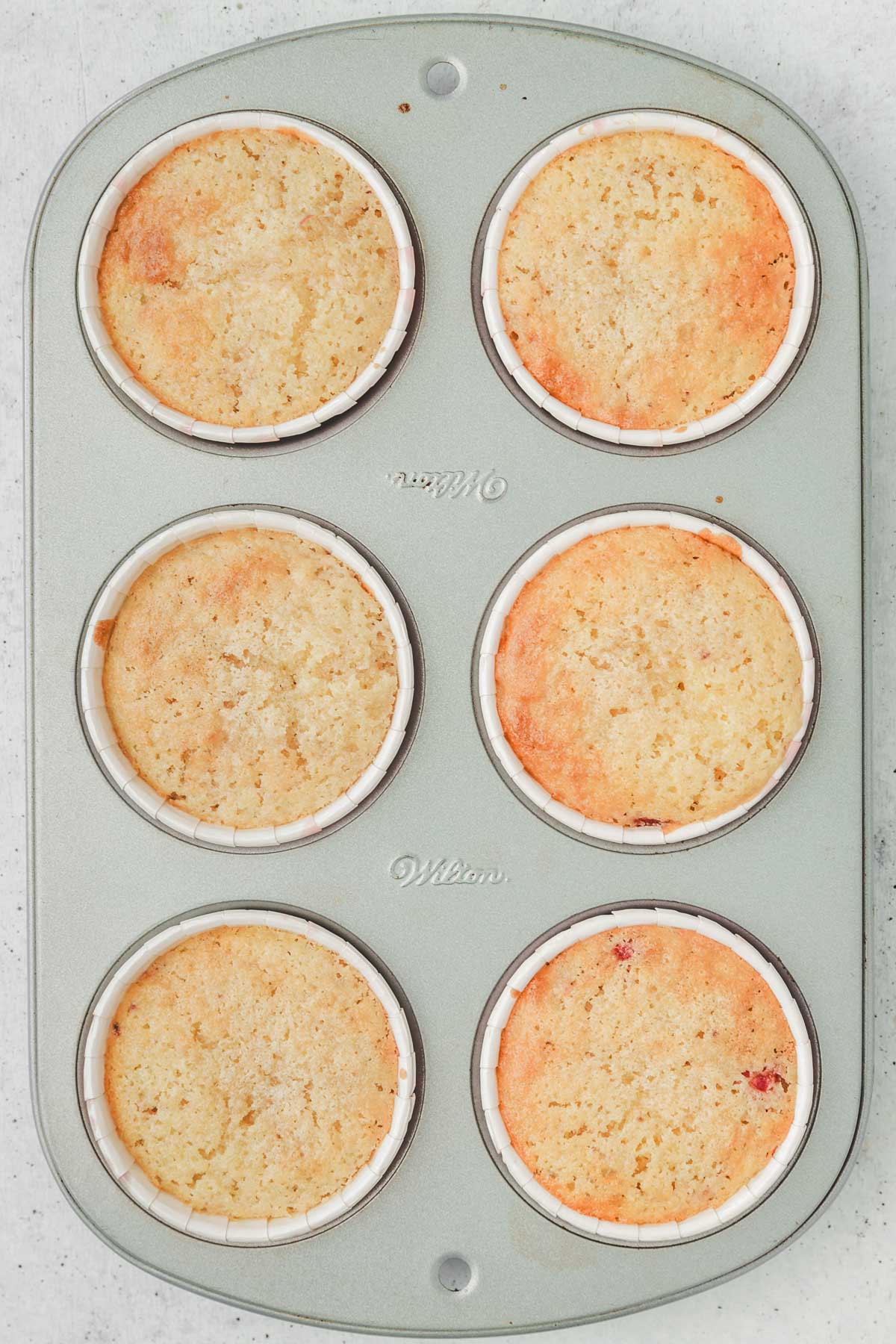 muffin pan with baked strawberry cupcakes