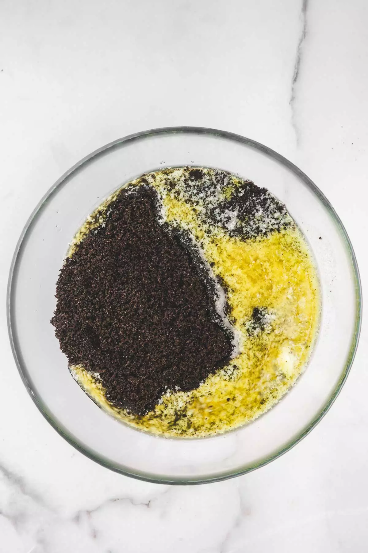 medium bowl with oreo crumbs and melted butter