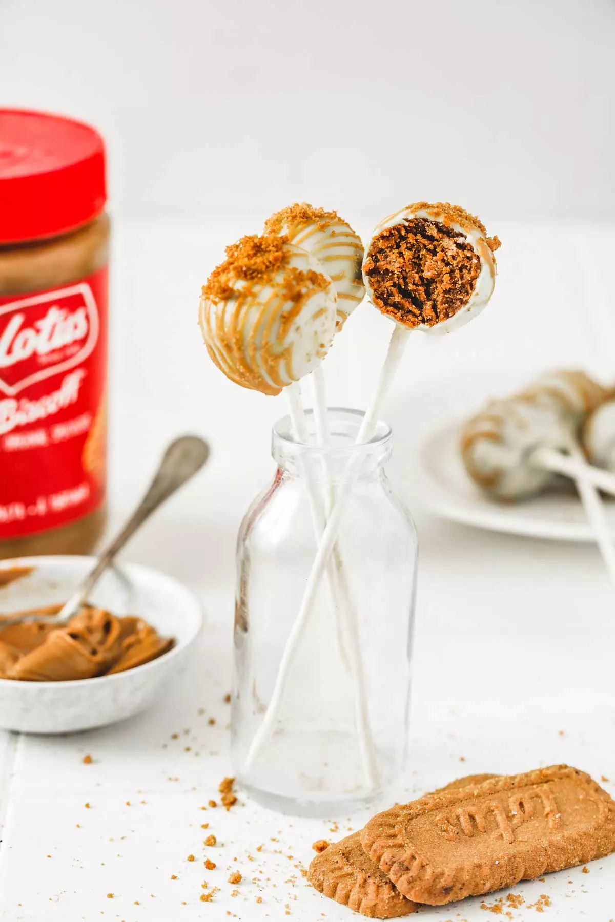 Biscoff cake pops with white chocolate drizzle on a plate