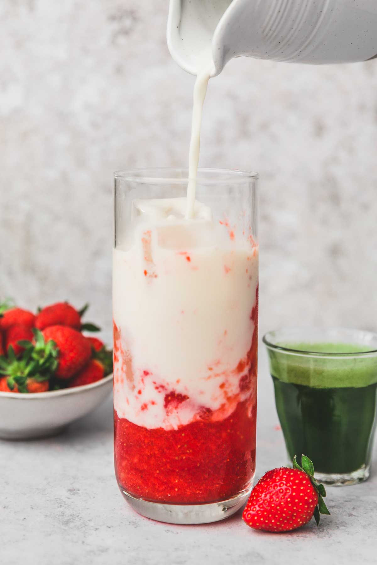 verre avec du lait et de la purée de fraise