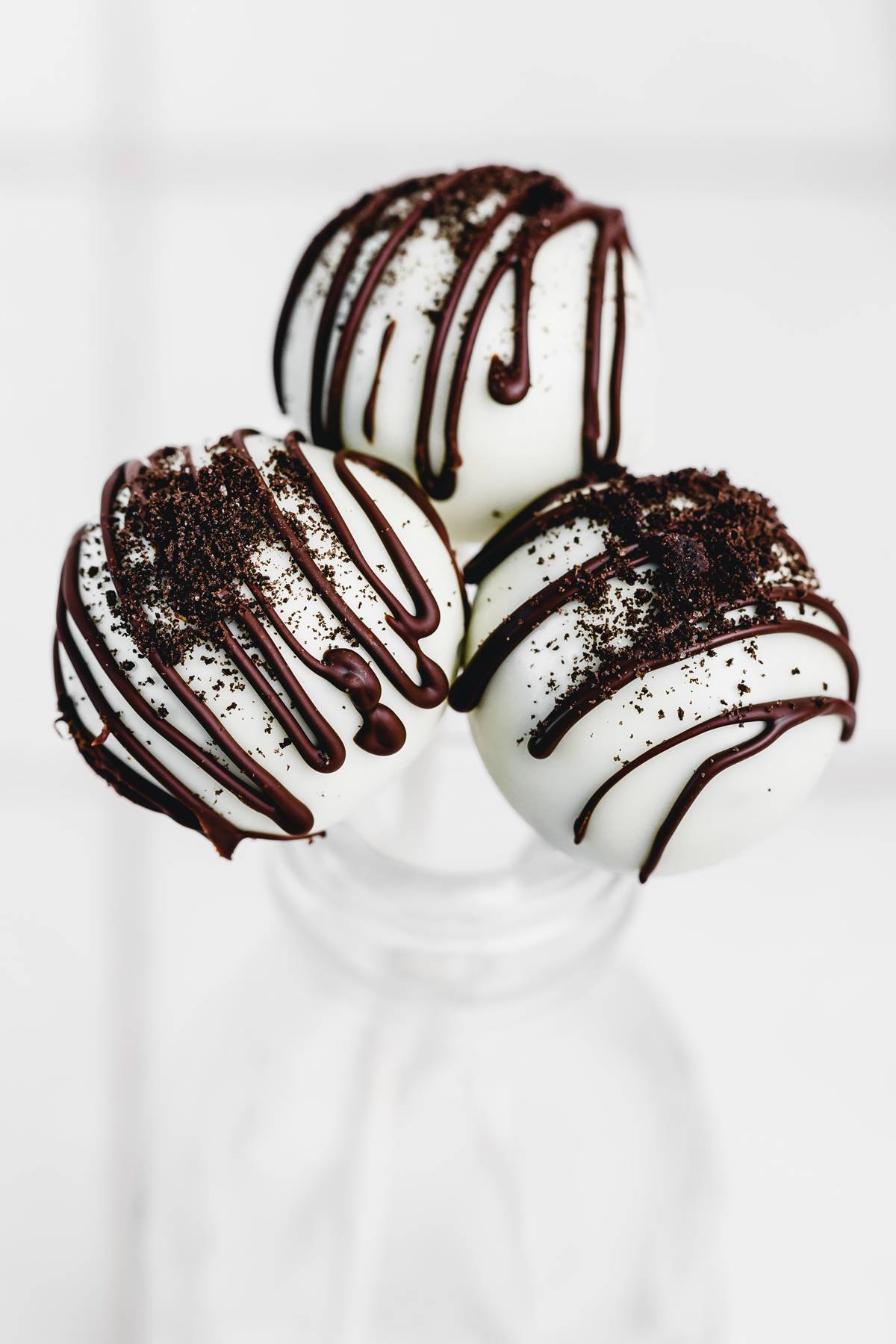 Finished Oreo cake pops coated in white chocolate and decorated with crushed Oreo cookies, perfect for parties and holidays.