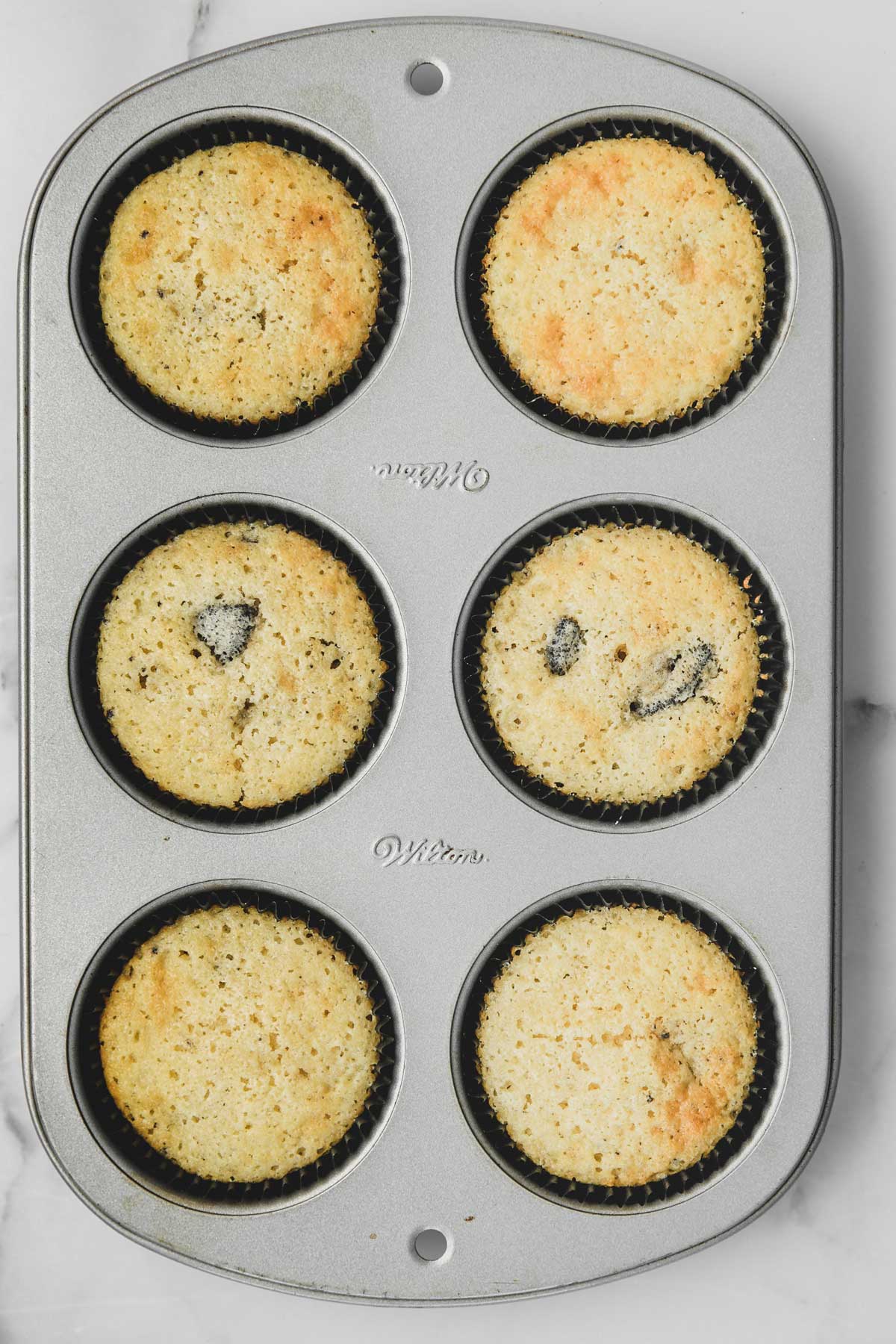 baked vanilla oreo cupcakes in a muffin pan