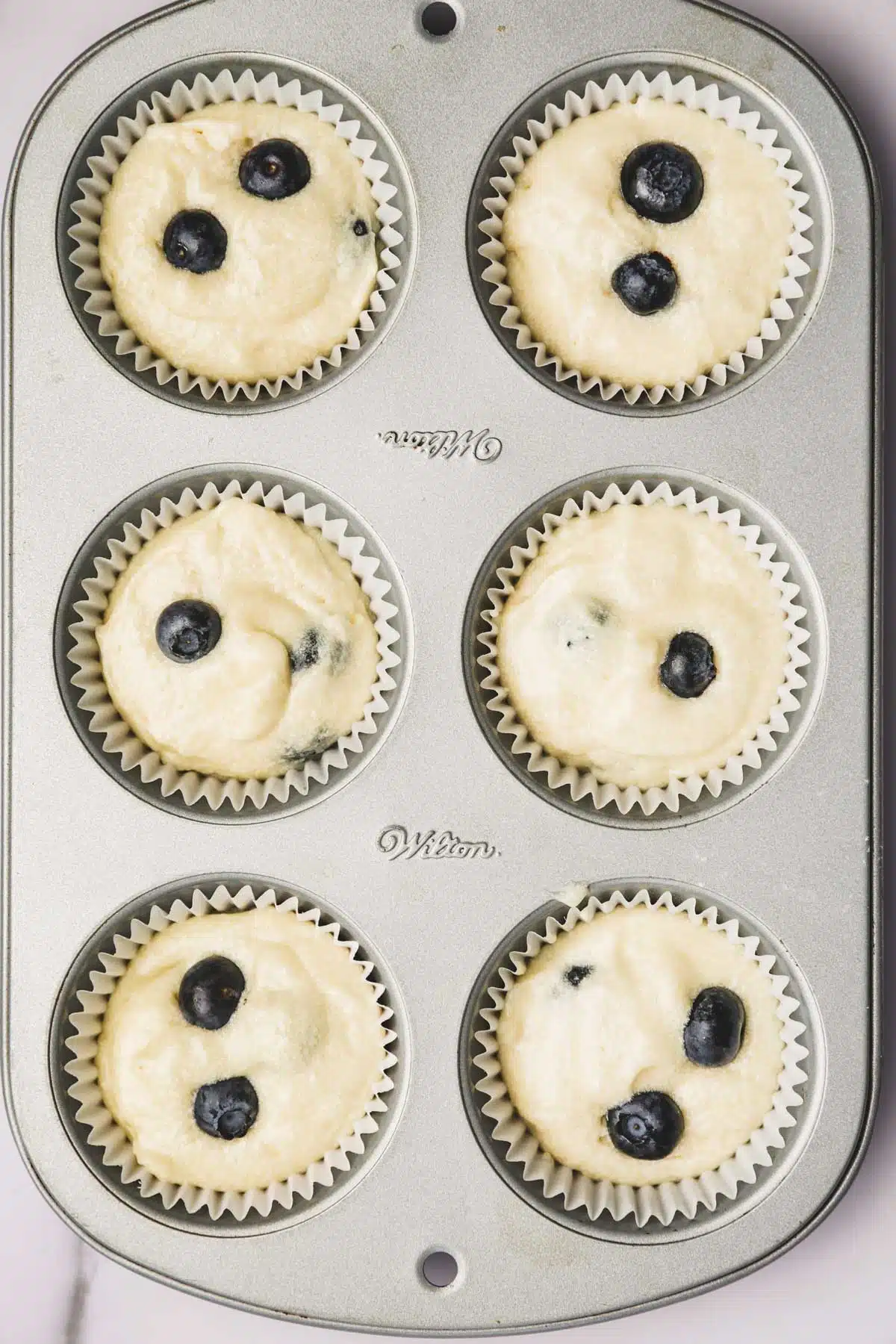 cupcakes pan with blueberry cupcake batter