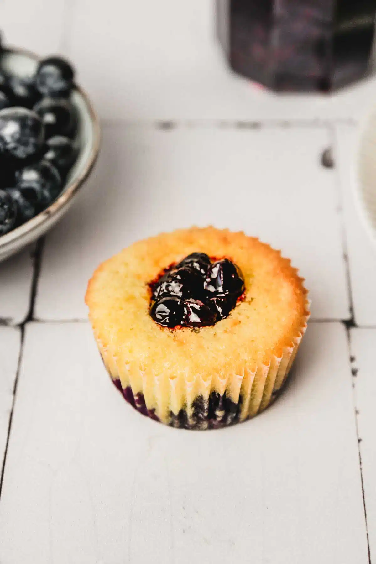 one cupcake on a table with blueberry filling