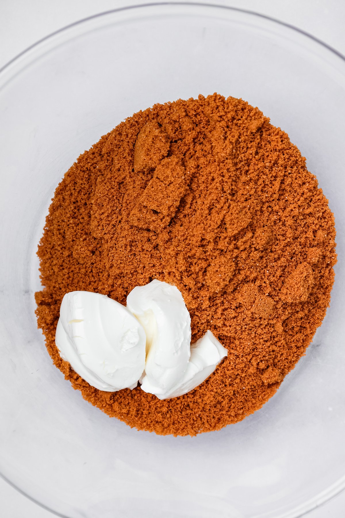 bowl with crushed cookies and cream cheese for biscoff cake pops