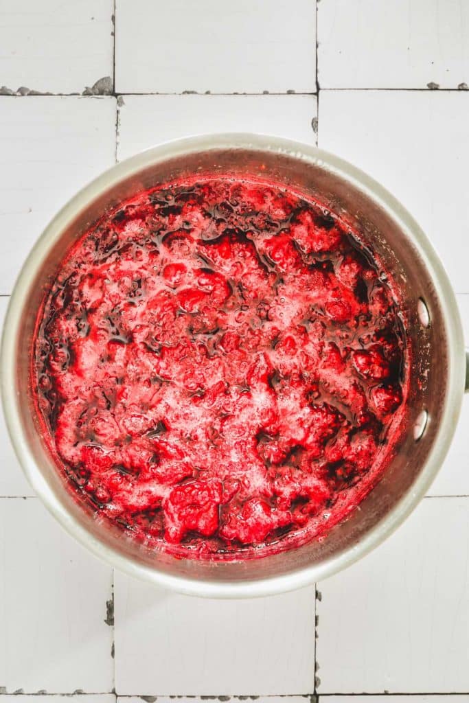 saucepan with raspberries and sugar cooking for compote
