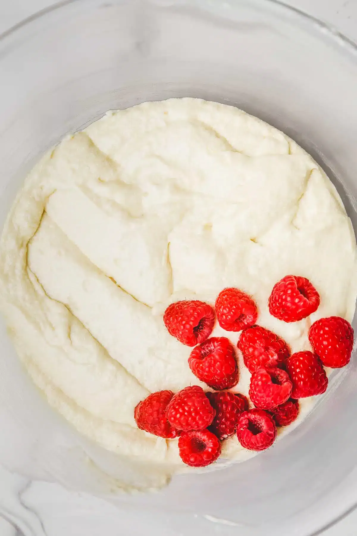 mixing bowl with cake batter and raspberries